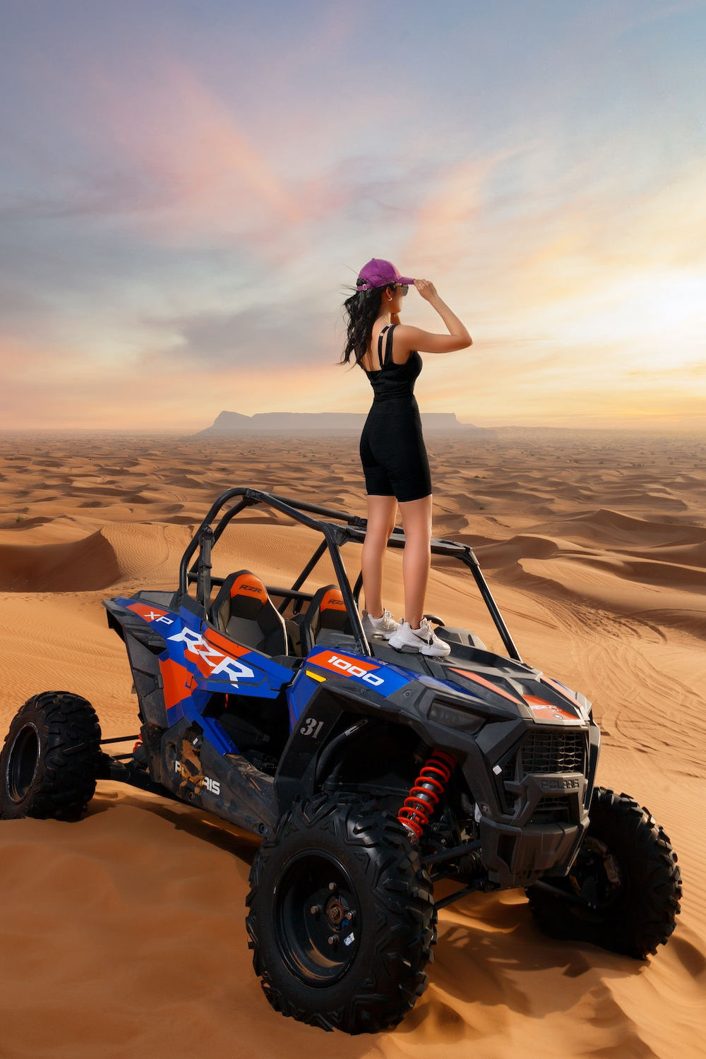 Woman standing on top of a quad bike wearing athletic outfit